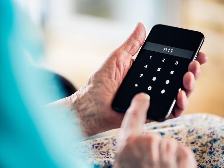 person holding a mobile phone dialing 9-1-1
