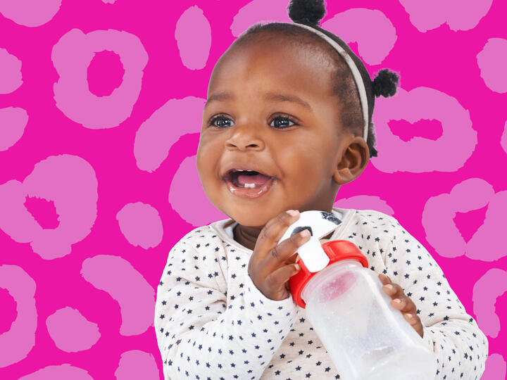 little girl smiling holding a cup