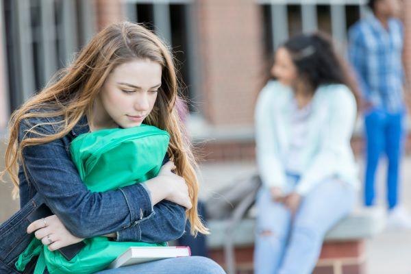 Teenage girl holding backpack