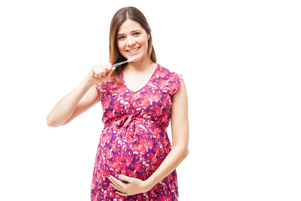 pregnant woman holding a toothbrush