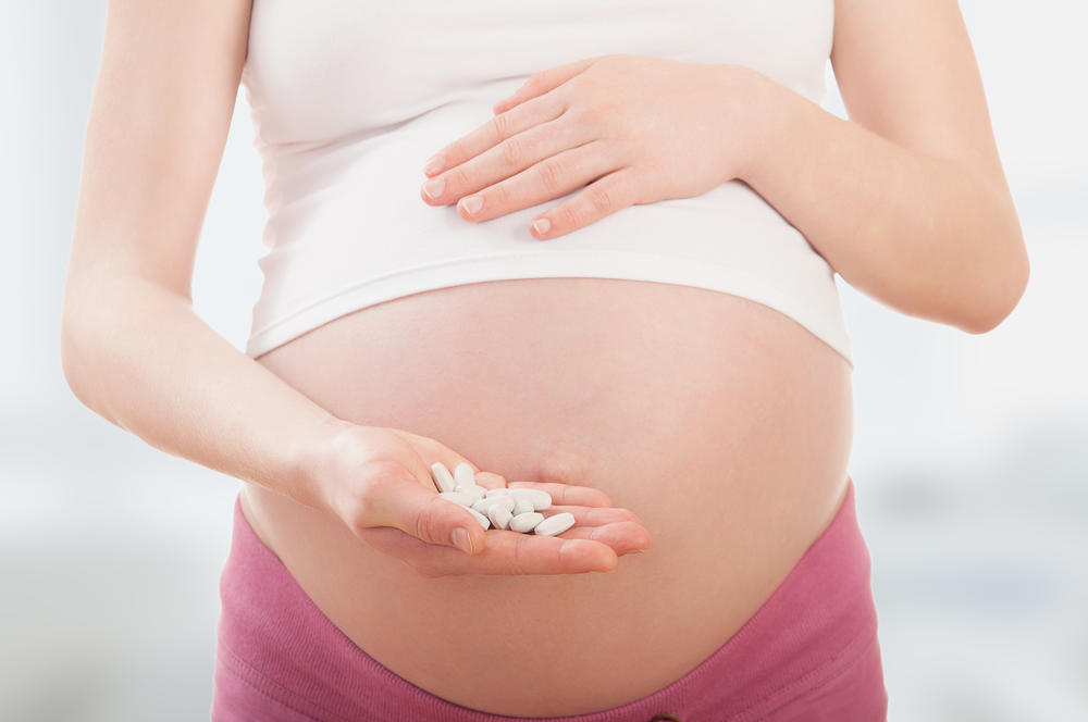 pregnant woman holding medication