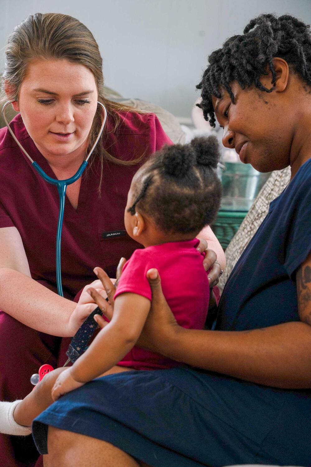 home visiting staff checking a babies heart beat