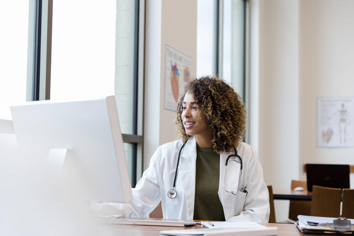 Physician at computer typing