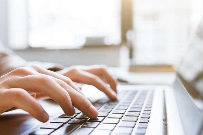 Photo of person typing on laptop