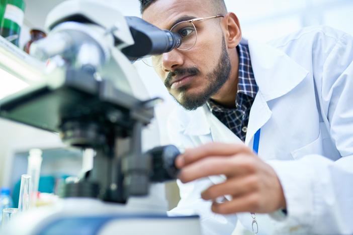 Scientist looking through microscope
