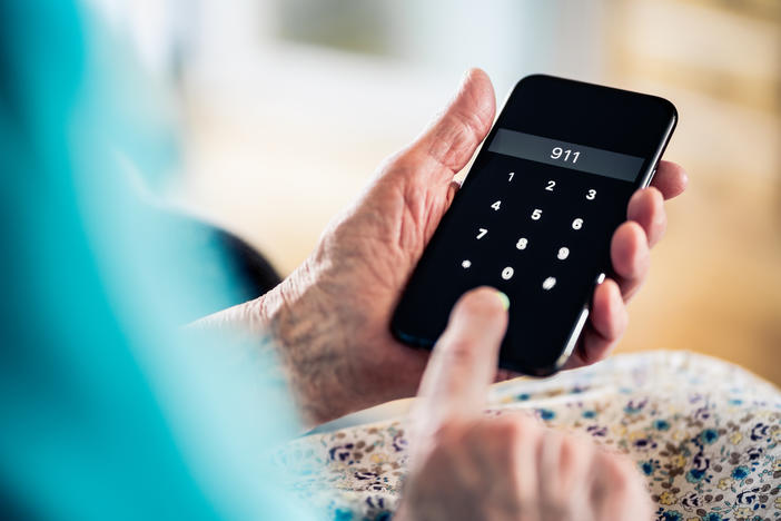 person holding a mobile phone dialing 9-1-1