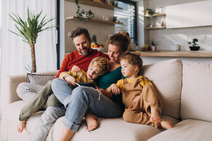 Family reading together on the sofa at home.