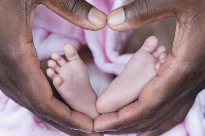 fathers hands holding an infants feet